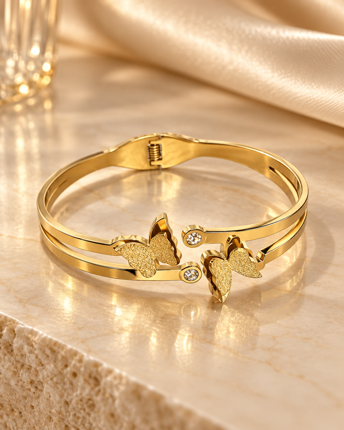 Noor gold-tone stainless steel butterfly cuff bracelet on champagne marble