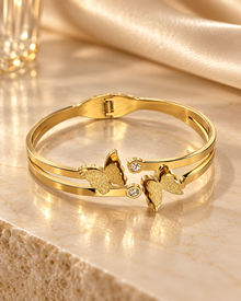 Noor gold-tone stainless steel butterfly cuff bracelet on champagne marble