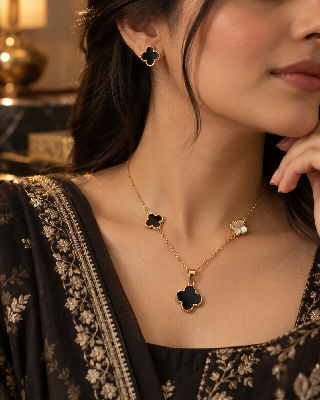 Zaria Gold black clover pendant necklace and stud earrings styled with formalwear