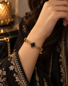 Zaria Gold black clover bracelet worn with embroidered black formal outfit