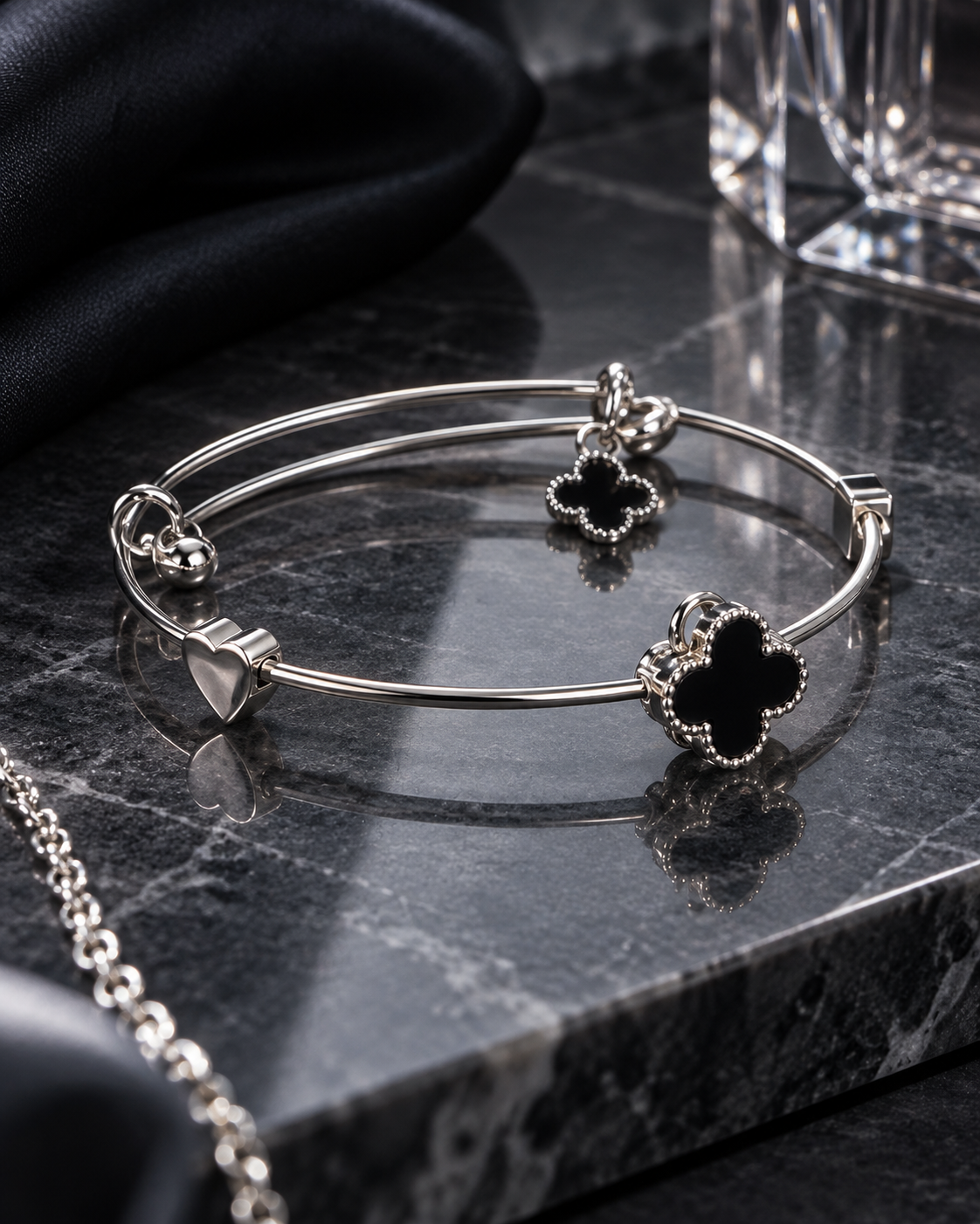 Zaria Silver black clover bracelet displayed on dark marble