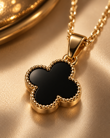 Close-up of Zaria Gold black clover pendant with textured border detail