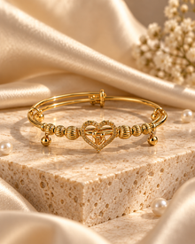 Ayla anti-tarnish gold heart bracelet with textured beads on travertine display