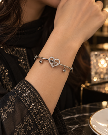 Elara silver heart bangle worn with an elegant black embroidered outfit