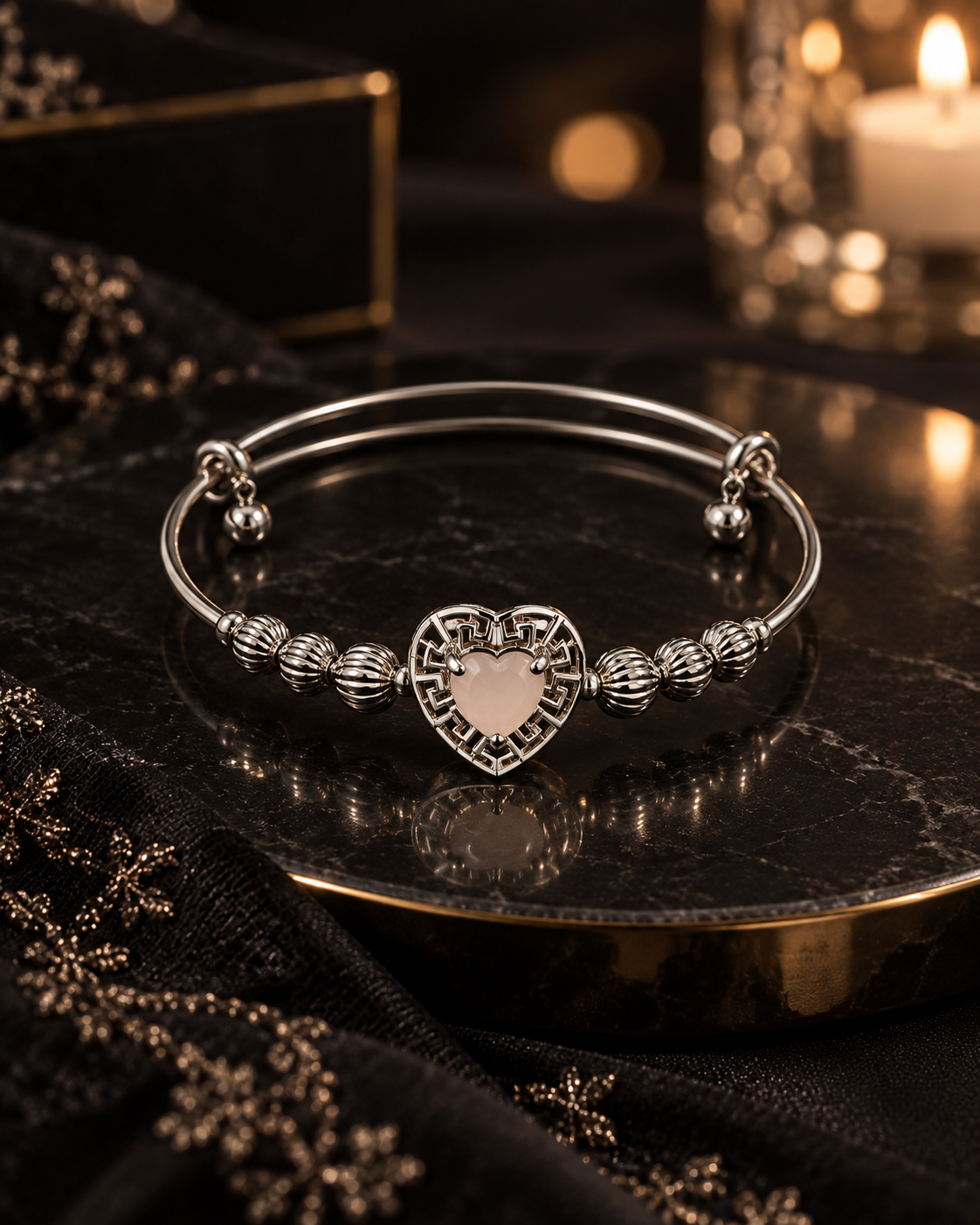 Mira Silver heart charm bangle with textured beads displayed on dark marble