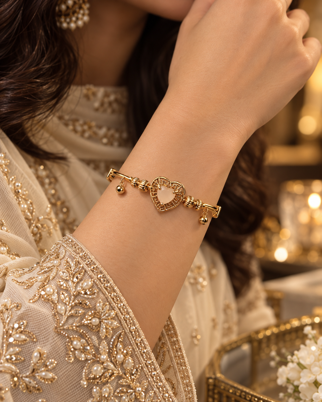 Mira Gold heart bangle worn with elegant cream embroidered formalwear