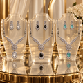 Elysia Winged Drop Jewellery Set in Clear, Black and Aqua displayed together