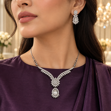 Woman wearing the Clear Elysia Winged Drop necklace and matching earrings
