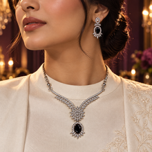 Woman wearing the Black Elysia Winged Drop necklace and matching earrings