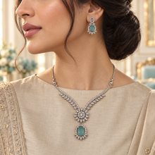 Woman wearing the Aqua Elysia Winged Drop necklace and matching earrings