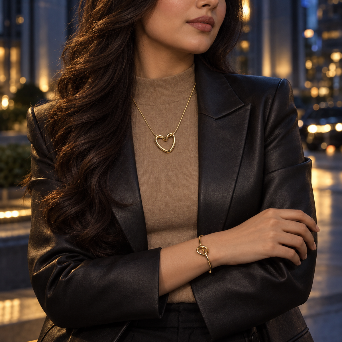 Woman wearing the Gold Nova Loop Heart necklace and bracelet with a modern evening outfit