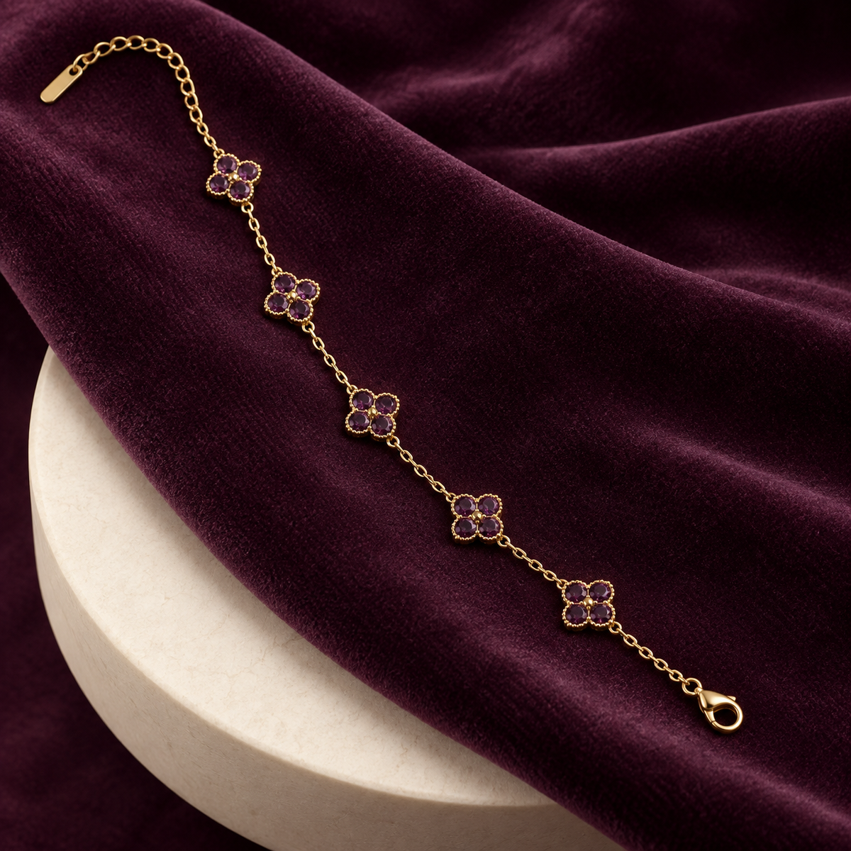 Liora Purple crystal clover bracelet displayed on deep plum velvet