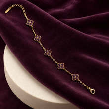 Liora Purple crystal clover bracelet displayed on deep plum velvet