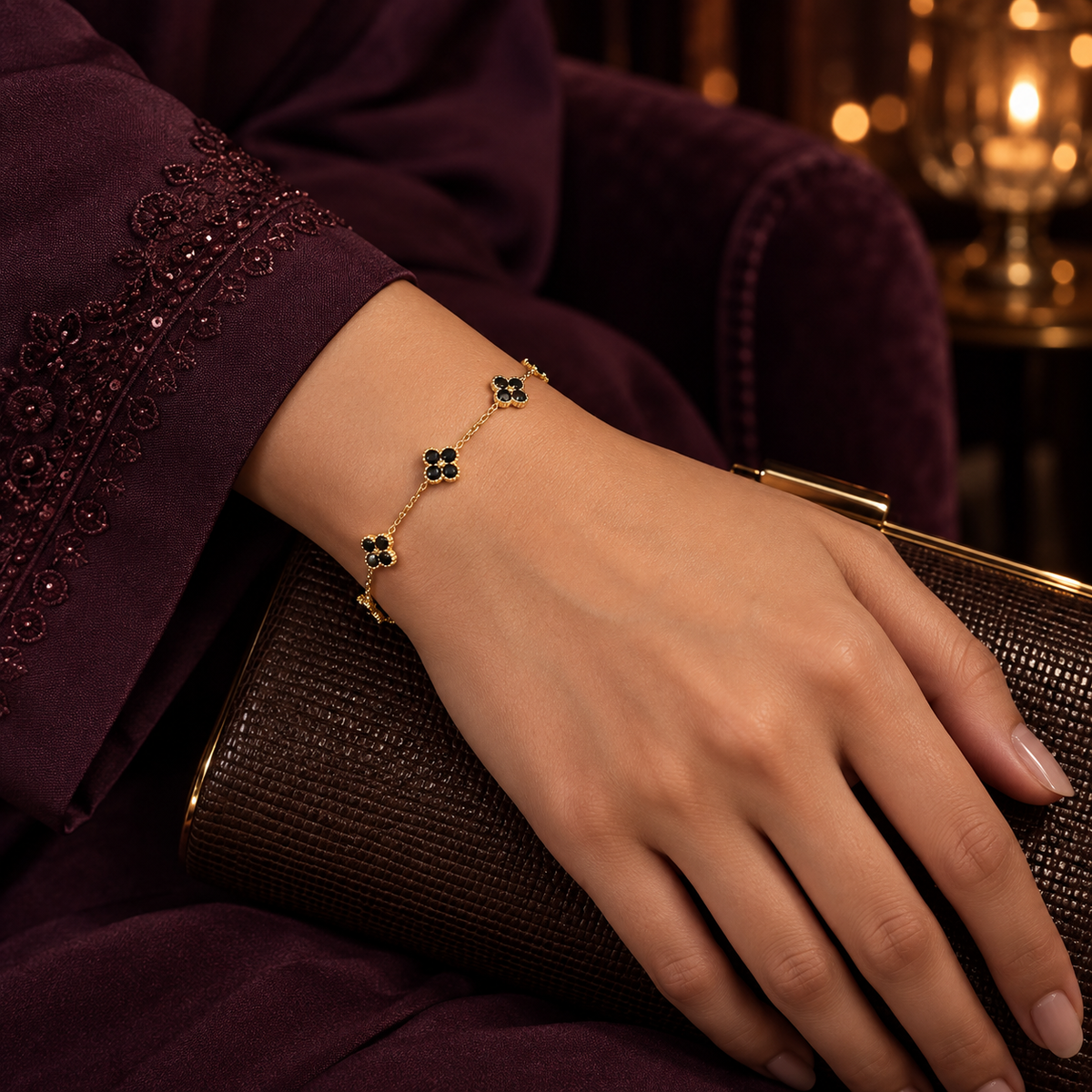 Woman wearing the Black Liora Crystal Clover Bracelet with a plum outfit