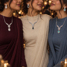 Three friends wearing Clear, Black and Aqua Elysia jewellery sets at an evening event