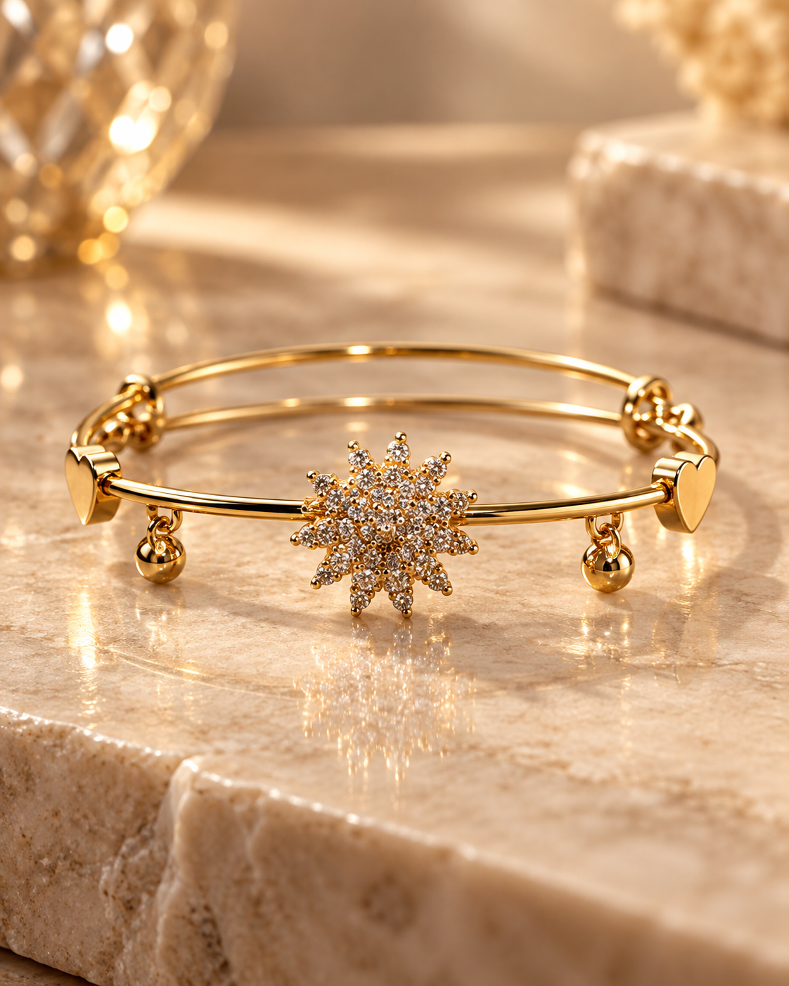 Gold starburst bangle bracelet with heart accents and dangling charms on a luxury stone surface