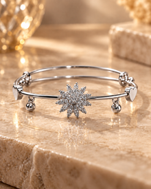 Silver starburst bangle bracelet worn on the wrist with elegant luxury styling