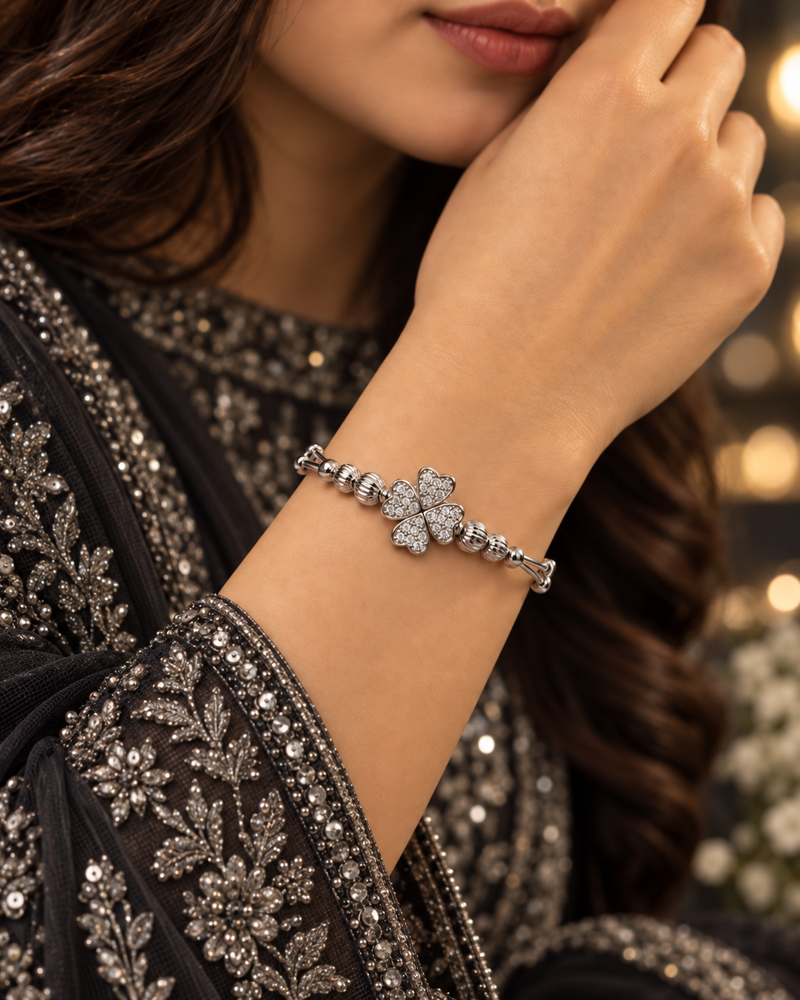 Silver clover bangle bracelet worn with elegant black embroidered formalwear