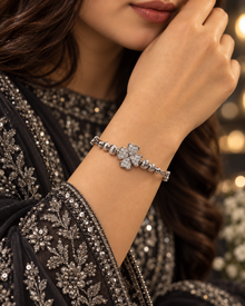 Silver clover bangle bracelet worn with elegant black embroidered formalwear
