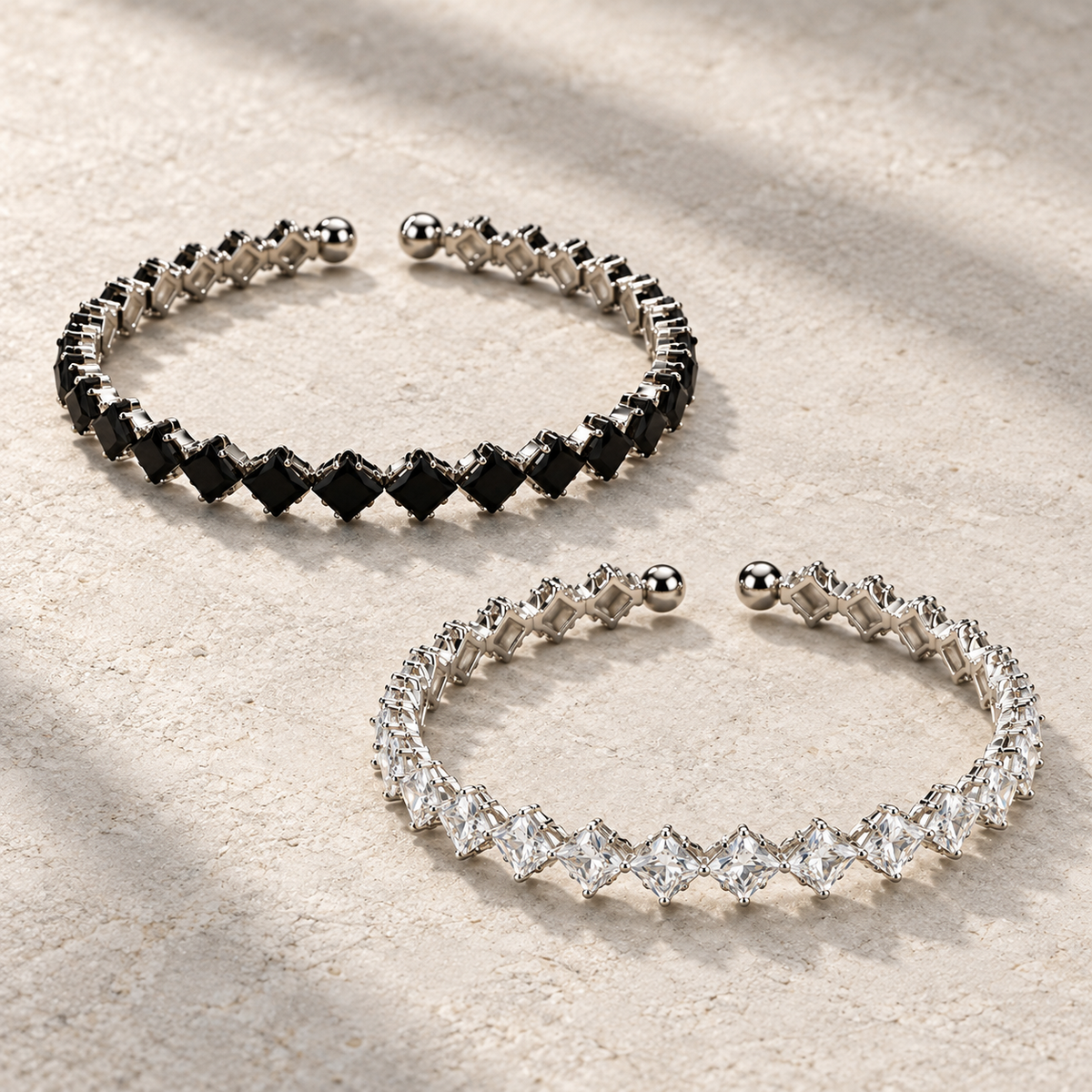 Elara Prism Bangle in Black and Clear, displayed separately on ivory stone.