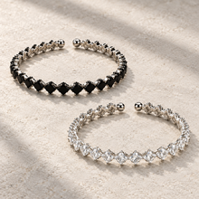 Elara Prism Bangle in Black and Clear, displayed separately on ivory stone.