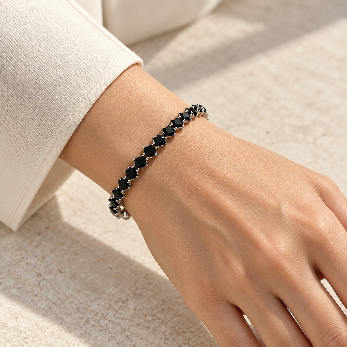 Black Elara Prism Bangle worn on a wrist with an ivory tailored sleeve.