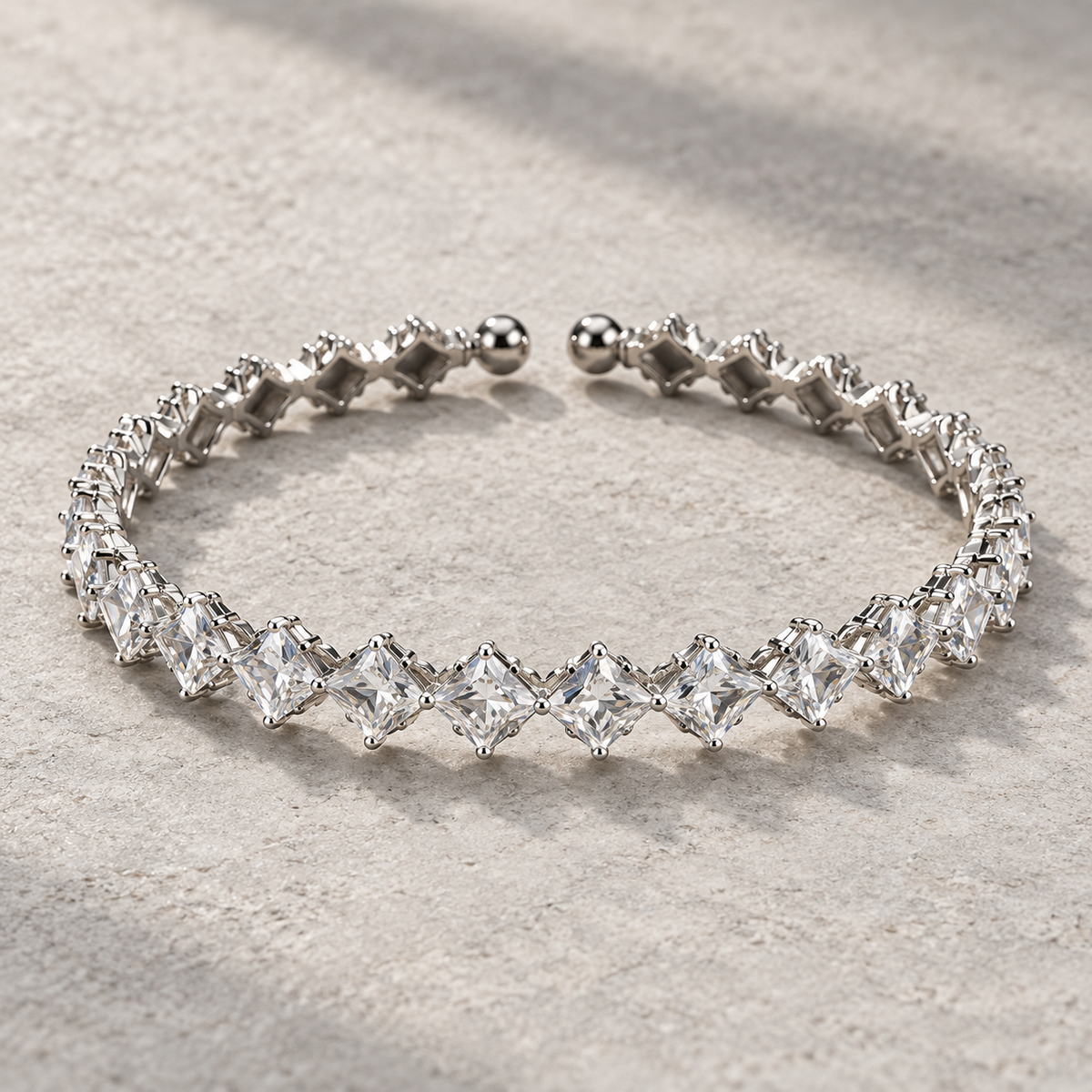 Clear Elara Prism Bangle with faceted diagonal square stones, silver-tone settings and rounded open-cuff ends.