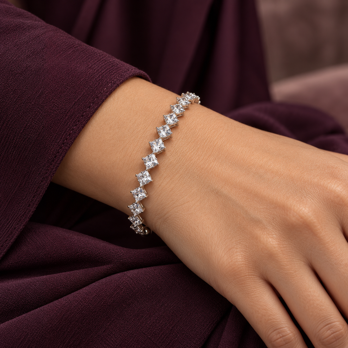 Clear Elara Prism Bangle worn on a wrist with a deep-plum sleeve.