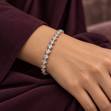 Clear Elara Prism Bangle worn on a wrist with a deep-plum sleeve.